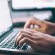 A pair of hands typing on the laptop keyboard